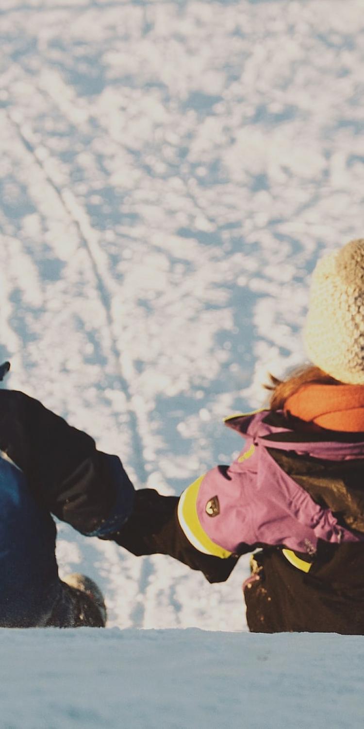 Two kids sitting on snow