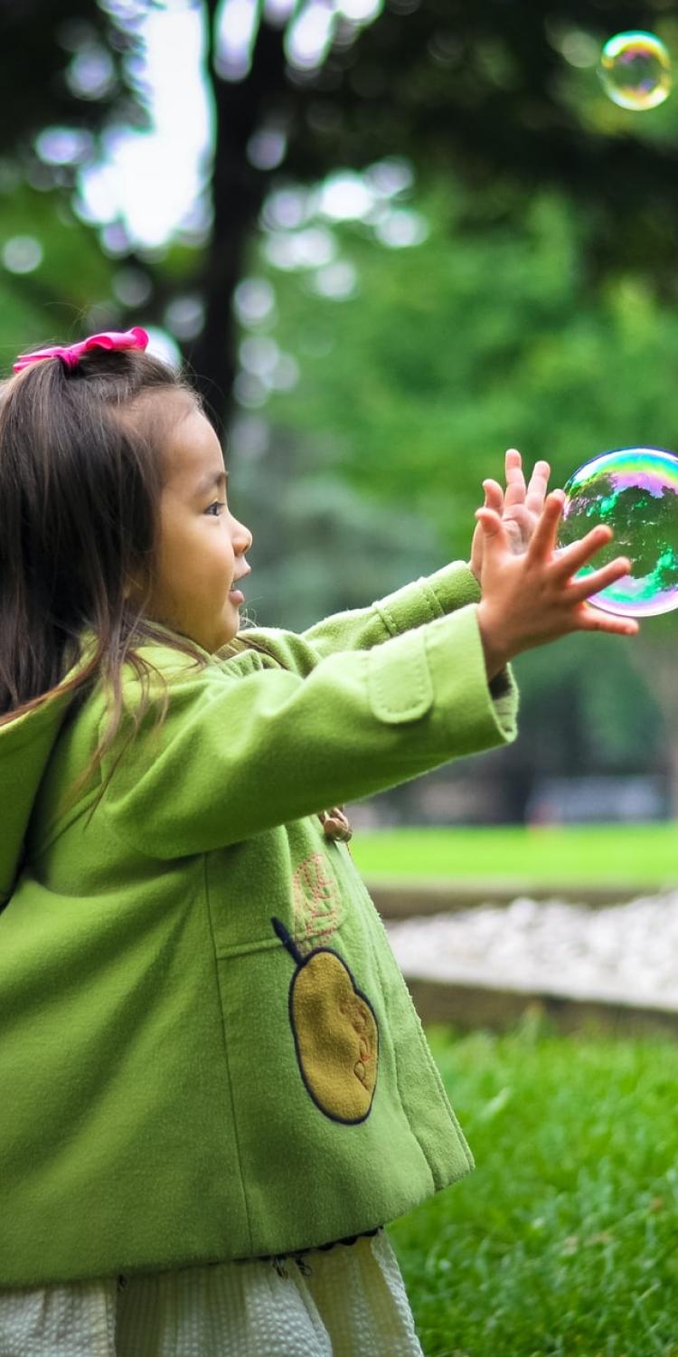 Girl trying to catch a bubble