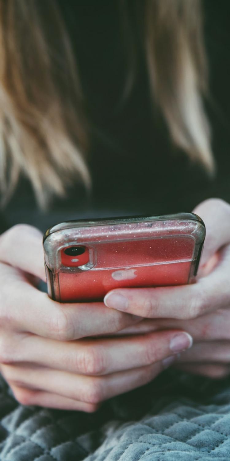 Person holding phone on bed