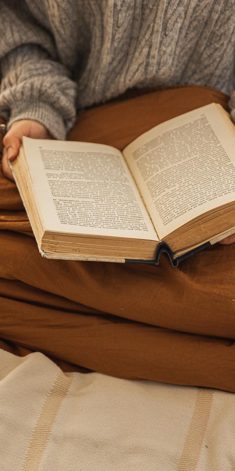 Person on bed with open book