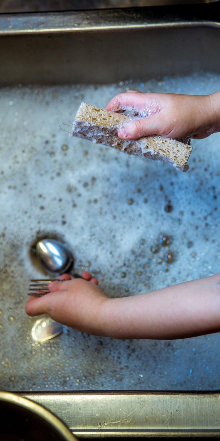 Child washing dishes