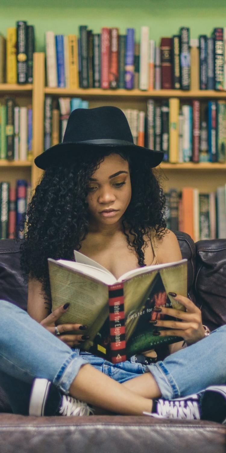 Girl reading book on couch