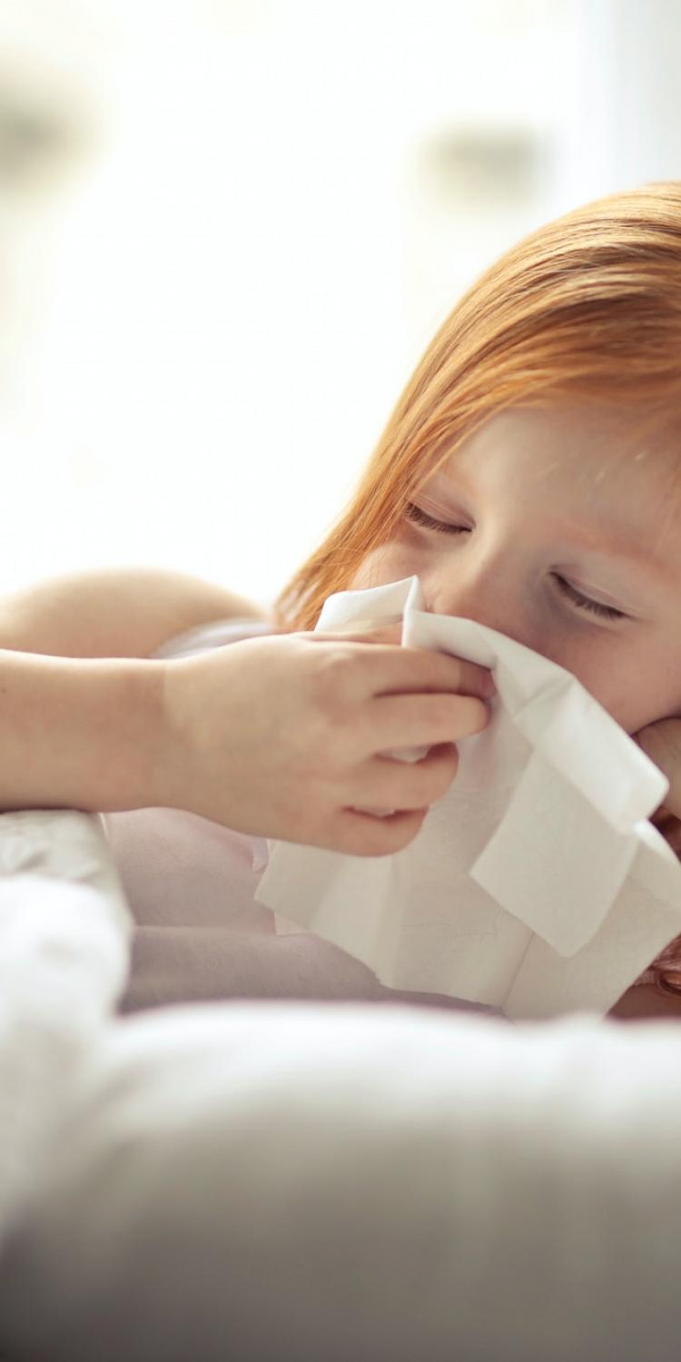 Young girl wiping her nose