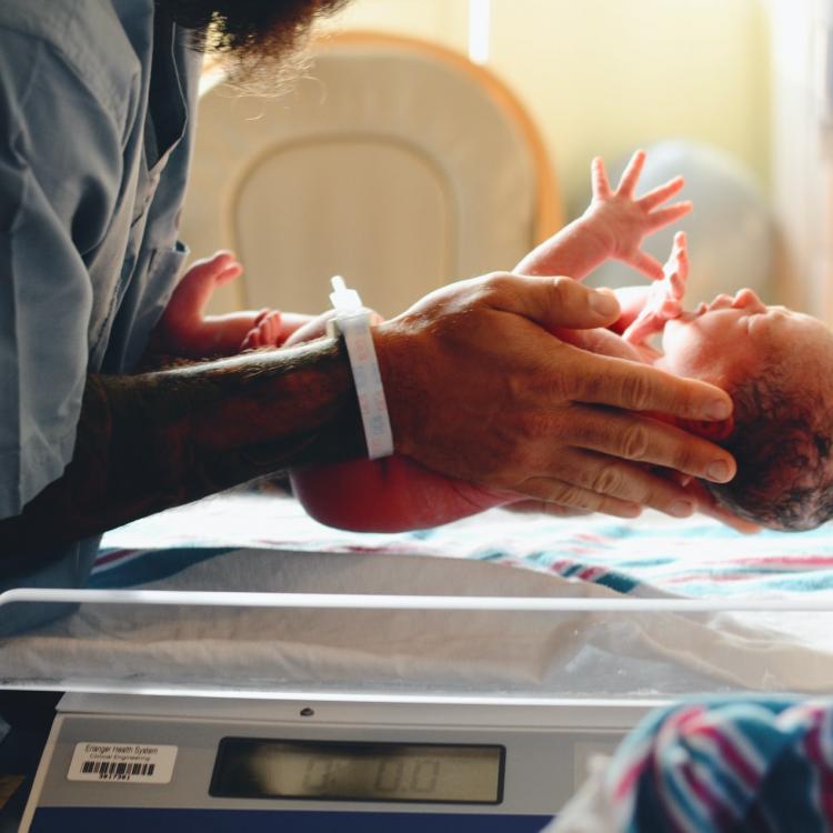 Newborn baby being held by doctor