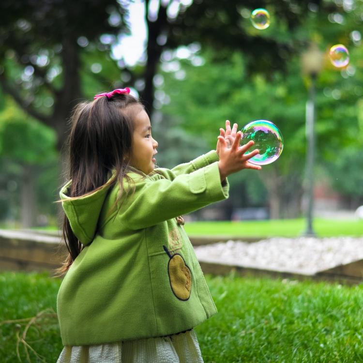 Girl trying to catch a bubble